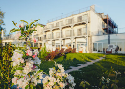 Außenansicht des Hotelgebäudes mit Liegestühlen auf einer Rasenfläche – Terrasse mit Zugang zu Spa oder Erholungsgarten.